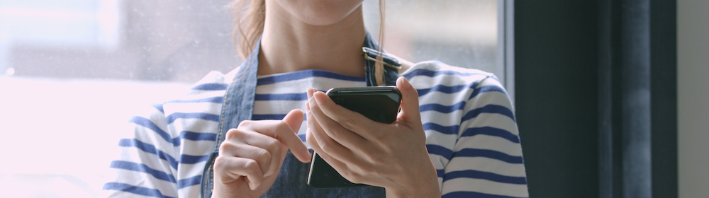 スマートフォンを操作するアルバイト従業員