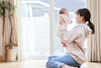 赤ちゃんを抱き上げる母親のイメージ