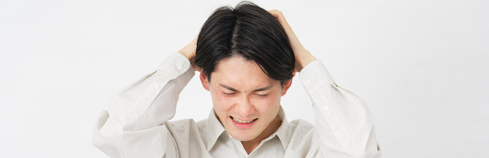 頭を抱えている男性